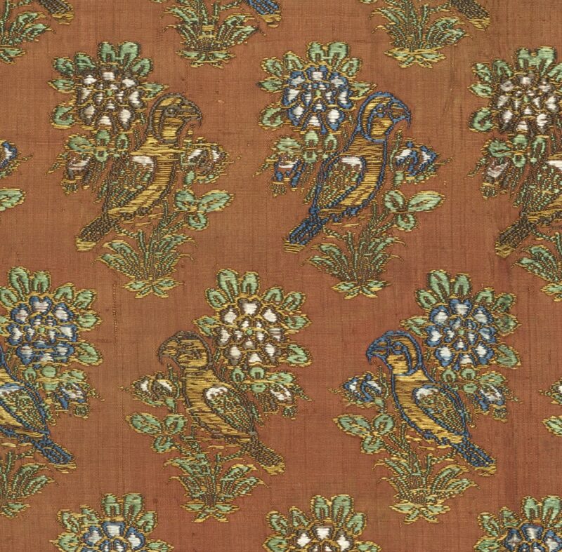 Broderie artisanale délicate illustrant une rose épanouie et un rossignol en fils de soie et d'or.